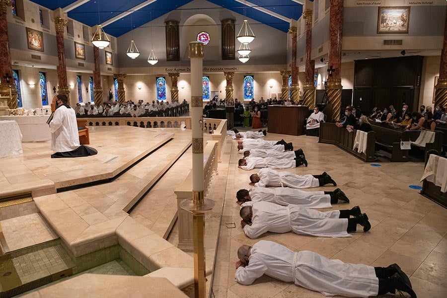 Candidates lie prostrate on the floor as Bishop Michael Olson recites the Litany of Saints.