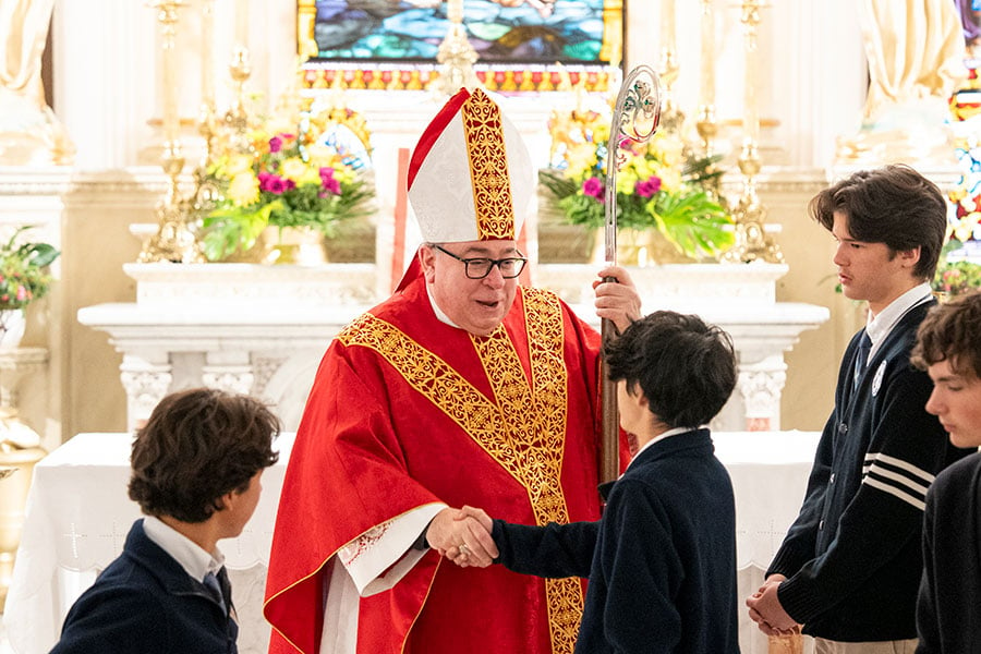 Bishop shakes hand of eighth grader