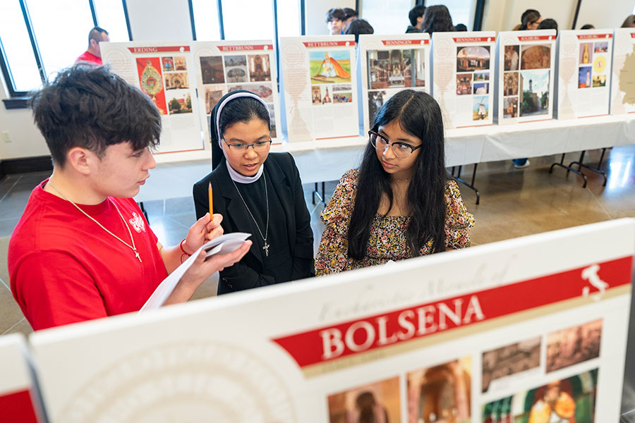Religious sister looks at exhibit with two teens