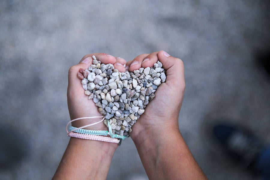 hands holding a gravel heart