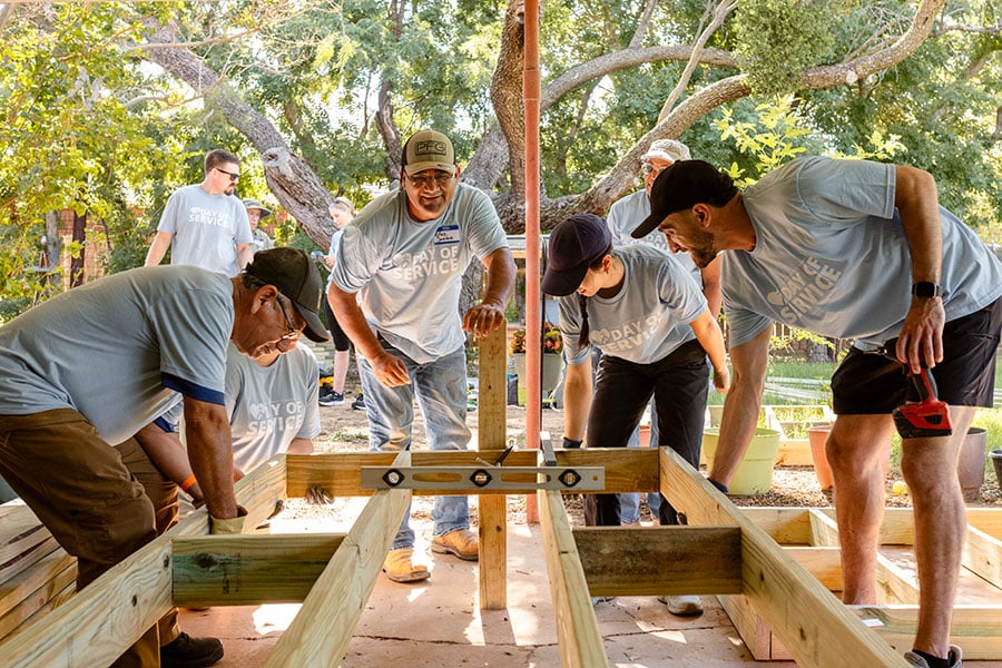 volunteers hold frame of ramp