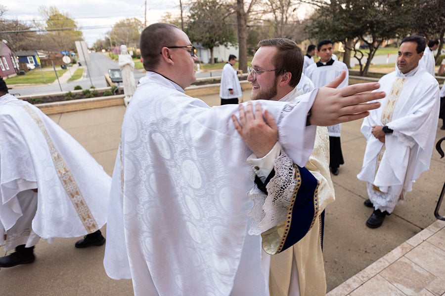 Deacon Blake Thompson hugs Father Brandon LeClaire