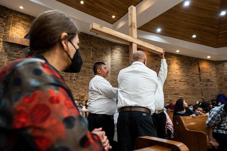Parishioners kneel as the cross is processed into the church. Father Thu Nguyen celebrated the Good Friday liturgy at St. Rita Church in Fort Worth on April 15, 2022.