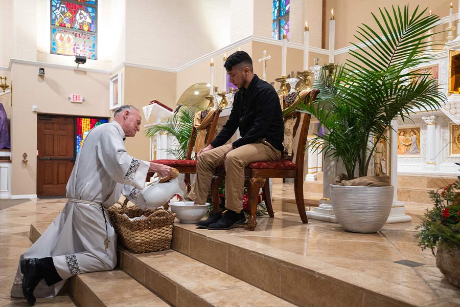 Fr. Mel Bessellieu washes the feet for parishioners including Jonathan Rodriguez, right, during the celebration of a Holy Thursday Mass at St. Ann Parish in Burleson, on April 14, 2022.  (NTC/Ben Torres)