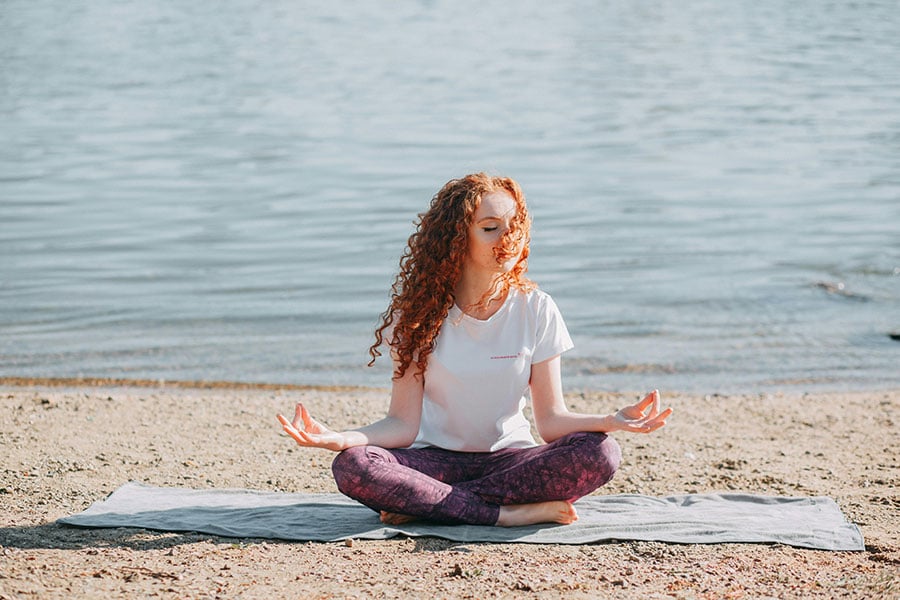 woman on beach doing yoga