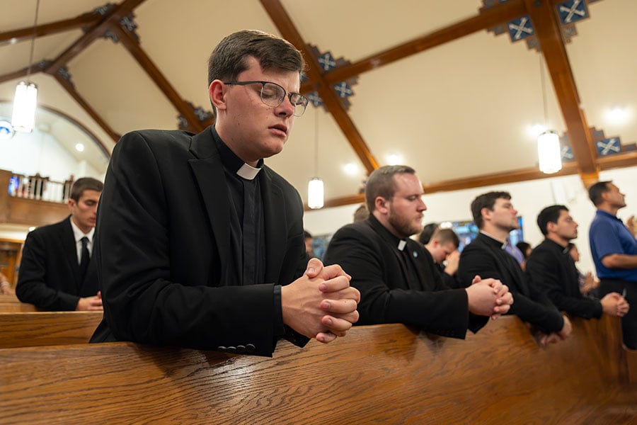 seminarians kneeling in prayer