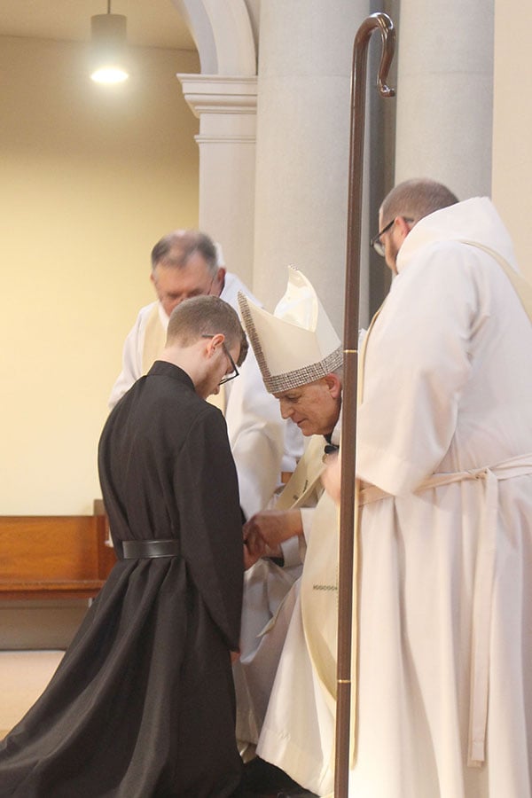 Brother Rother Hoffschwelle kneels before bishop