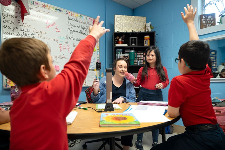 students and teacher at table