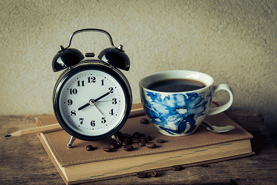 coffee cup book and alarm clock
