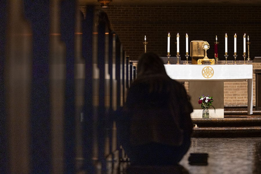 woman kneeling before monstrance