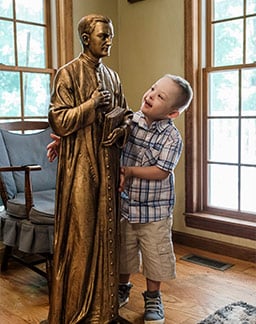 Mikey Schachle, 5, examines a statue of Father Michael McGivney at the home where he lives with his parents, Daniel and Michelle, and siblings in Dickson, Tenn., June 2, 2020. (CNS photo/Rick Musacchio, Tennessee Register)