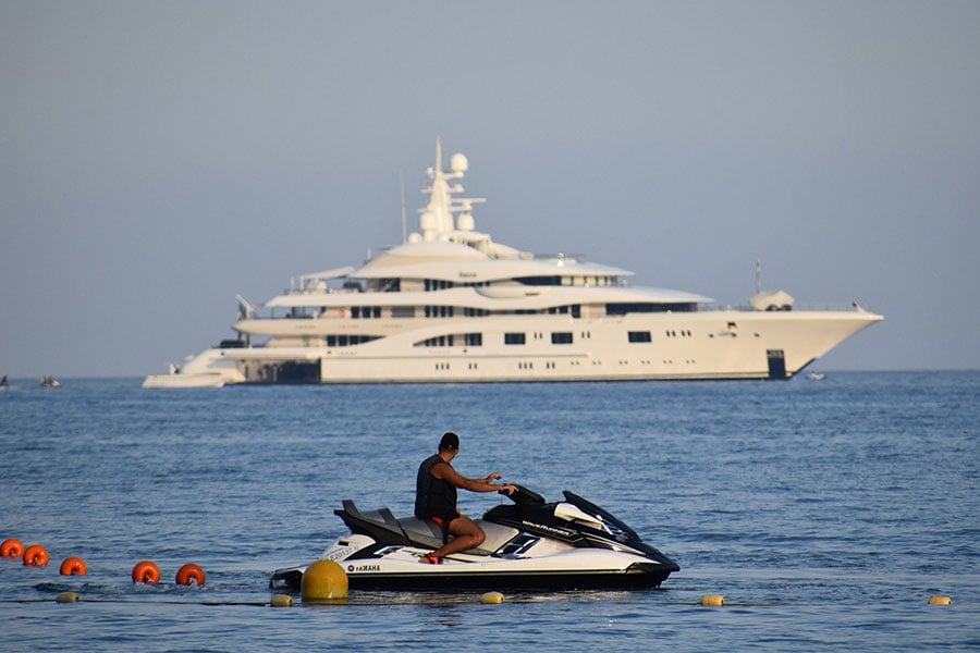 man on jetski looks at yacht