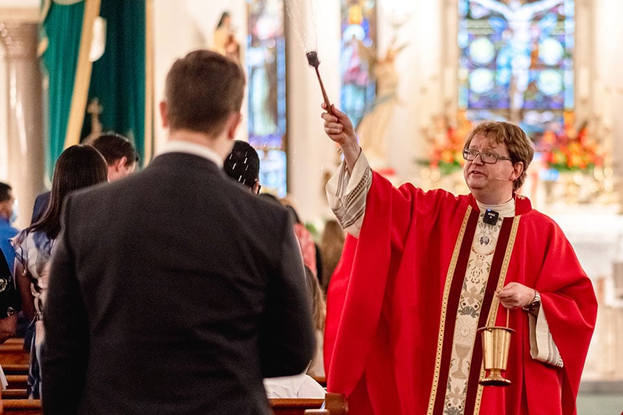 Father John Robert Skeldon, rector of St. Patrick Cathedral, blesses the congregation with holy water May 30, 2020. (NTC/Kenneth Munyer)