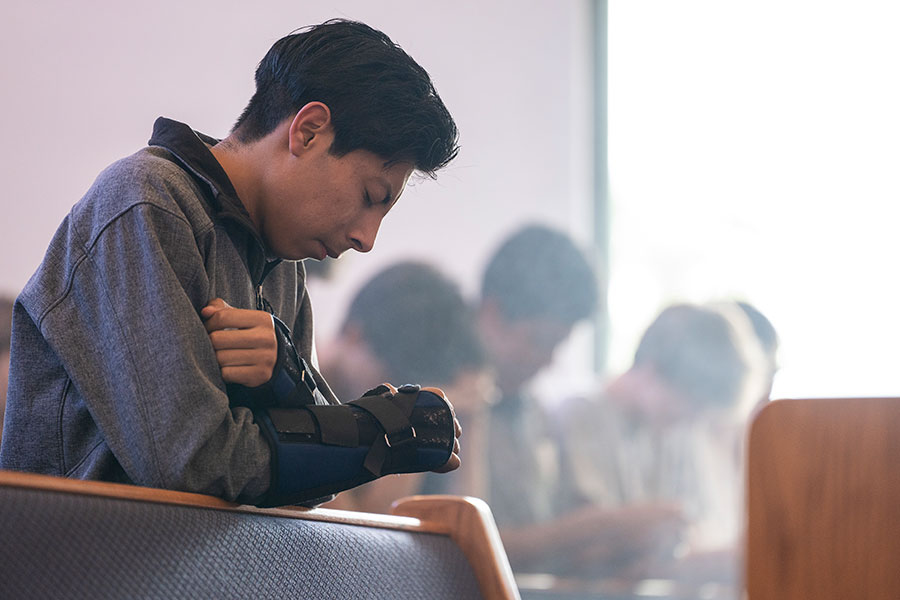 young men praying and kneeling
