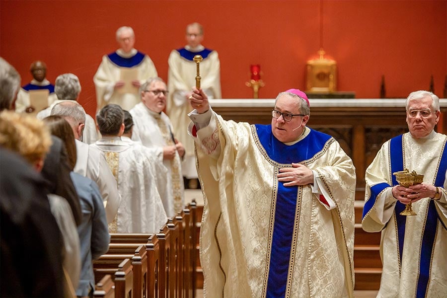 Bishop Michael Olson blesses the congregation and church building with holy water during the dedication Mass on February 22, 2022.