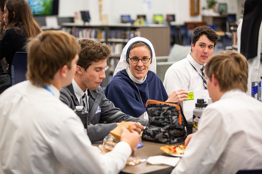 Sr. Marie Veritas, SV, talks with students at lunch as three members of the Sisters of Life religious order from New York City visit Nolan Catholic High School, Friday April 1, 2022.