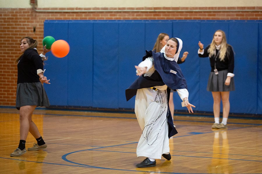 Sr. Mary Grace, SV, plays dodgeball with students as three members of the Sisters of Life religious order from New York City visit Nolan Catholic High School, Friday April 1, 2022.