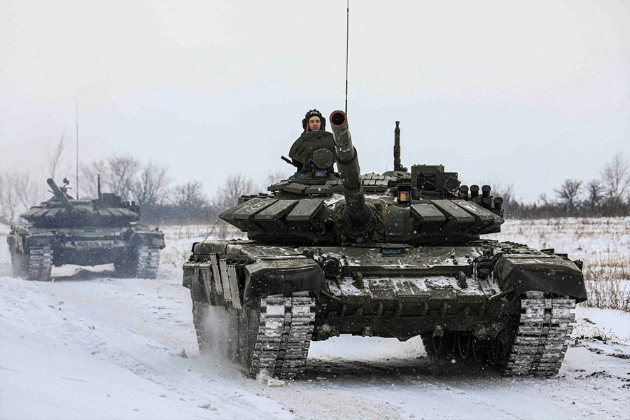 Members of the Russian armed forces drive tanks during military exercises in the Leningrad region of Russia in this handout photo released Feb. 14, 2022.