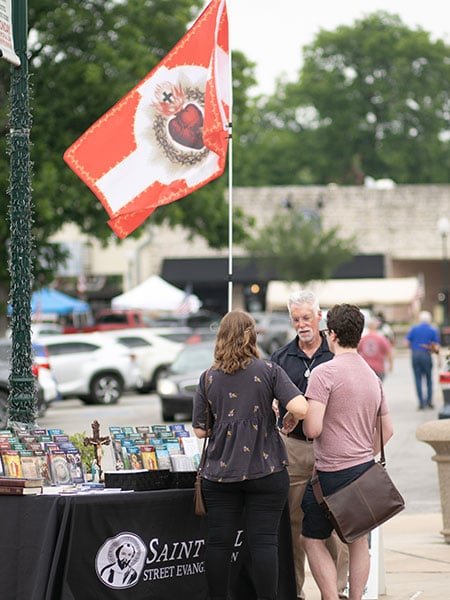 Randy Grasso,a member of the Saint Paul Steet Evangelization team,  talks and prays with Laura Tim and Irving Wruck as they visit the Granbury Town Square, Saturday, May 27, 2023.
