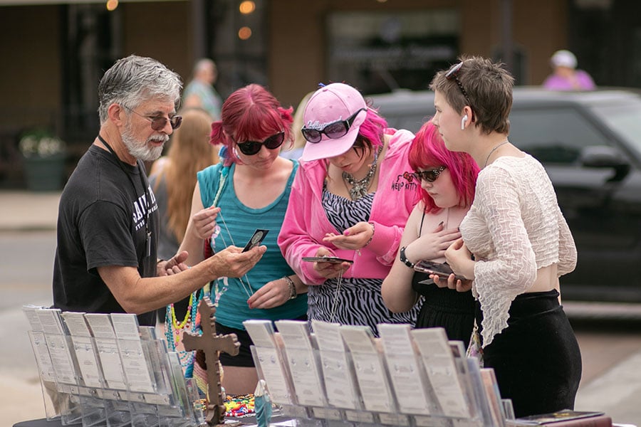 David Rollins, a member of the Saint Paul Steet Evangelization team, talks with Olivia Durfey, Harlee Graham, Vee Hewett and Mary Stiles, of Josua, as they visit the Granbury Town Square, Saturday, May 27, 2023.