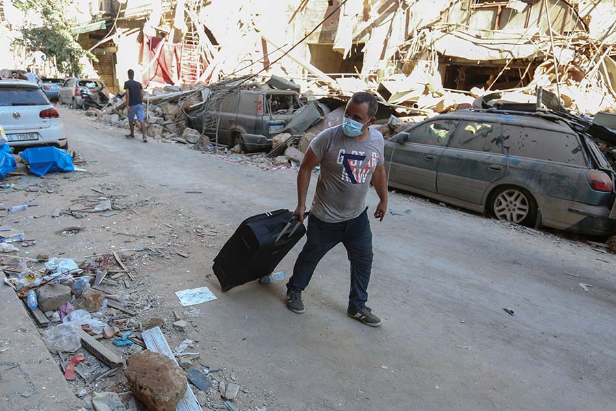 A man pulls his belongings along a street as he evacuates his damaged house in Beirut.