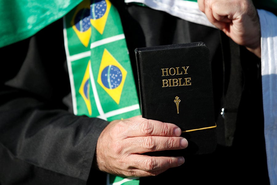 A Brazil fan in Moscow holds a Bible before a World Cup match.