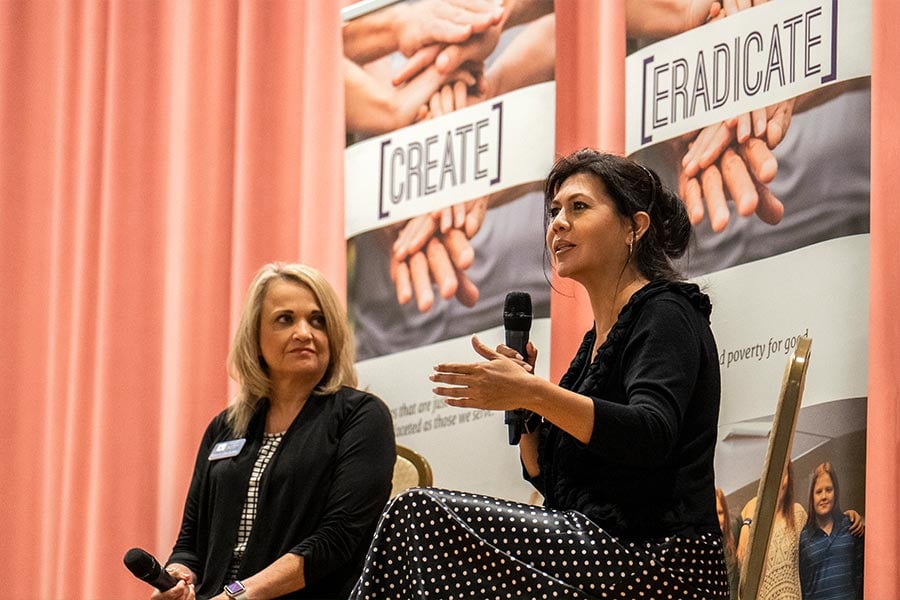 Elia Moreno, national director of Community Outreach for No Excuses University, addresses the audience during the Fifth Annual Poverty Summit hosted by Catholic Charities Fort Worth Northwest Campus as CCFW Chief Service Officer Ronna Huckaby listens on May 10, 2022. (NTC/Juan Guajardo)