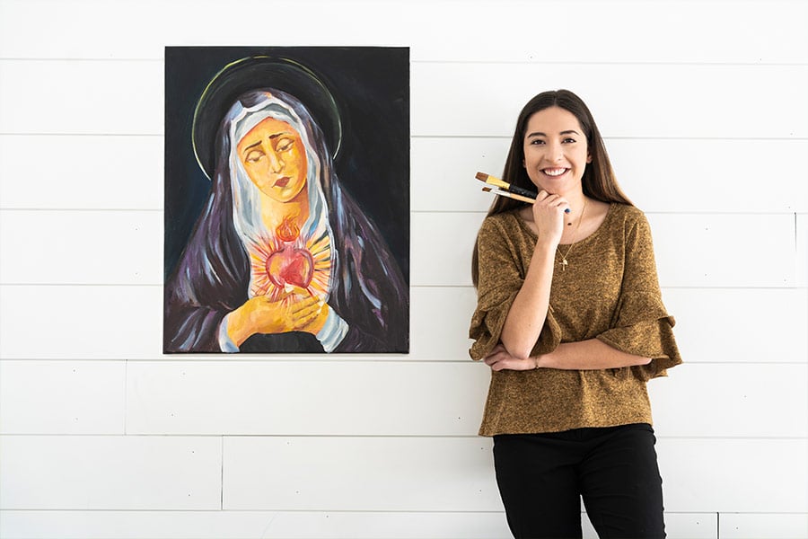 Artist Maria Diaz stands next to one of her paintings of the Virgin Mary. (NTC/Juan Guajardo)