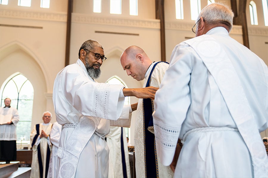 Newly ordained transitional Deacon Randolph Edward Hopkins is assisted in vesting with the stole and dalmatic that are symbolic of the diaconate. (NTC/Juan Guajardo)