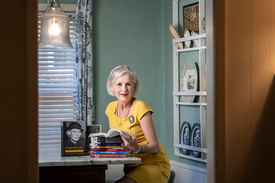 Wanda Styrsky poses with books about Dorothy Day at her home in Fort Worth April 29, 2020. (NTC/Juan Guajardo)