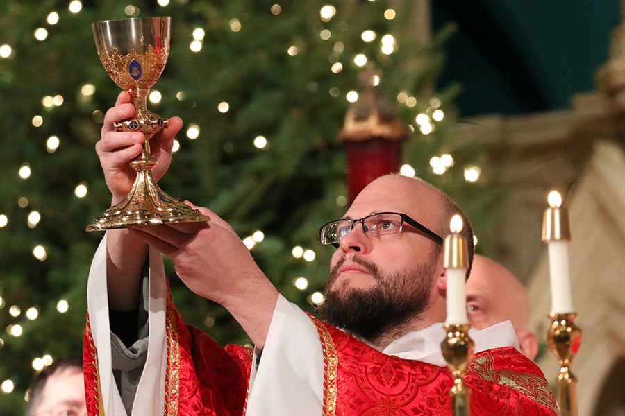 Father John-Mary Johannssen elevates the chalice during a Mass.