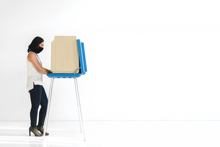 A younger woman votes at a voting station.