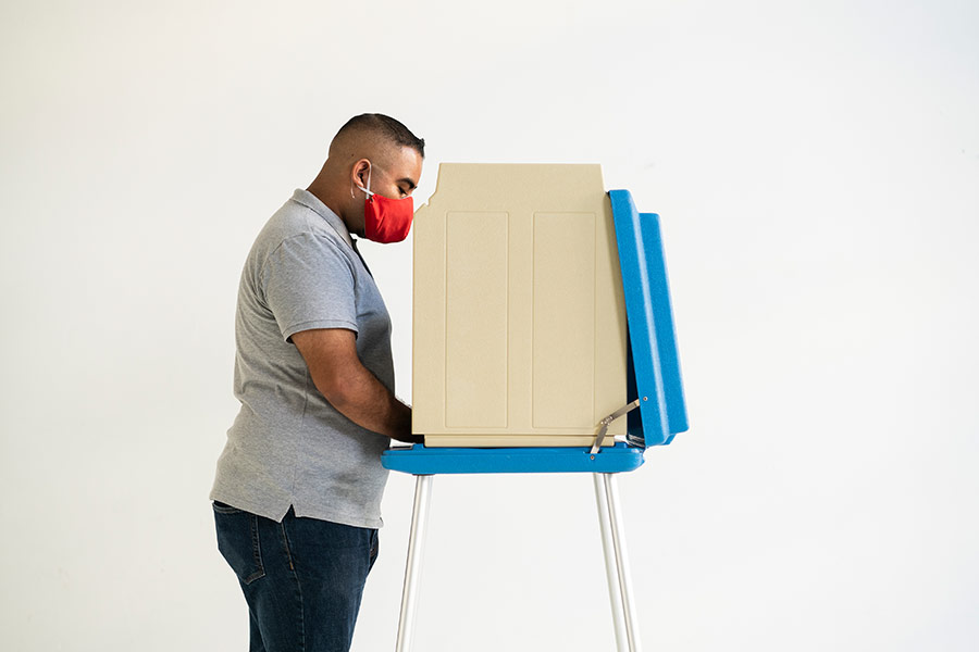 A younger man votes at a voting station.
