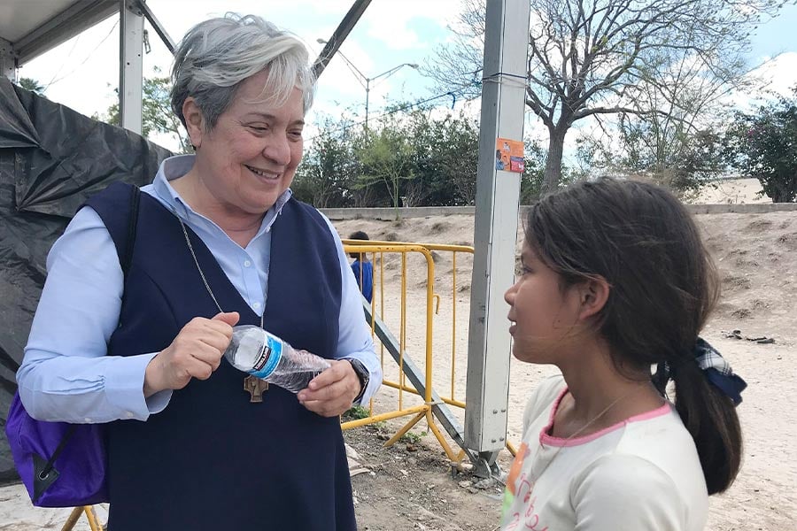 Sister Norma Pimentel, director of Catholic Charities of the Rio Grande Valley in Texas, speaks with a young resident of a tent camp in Matamoros, Mexico.