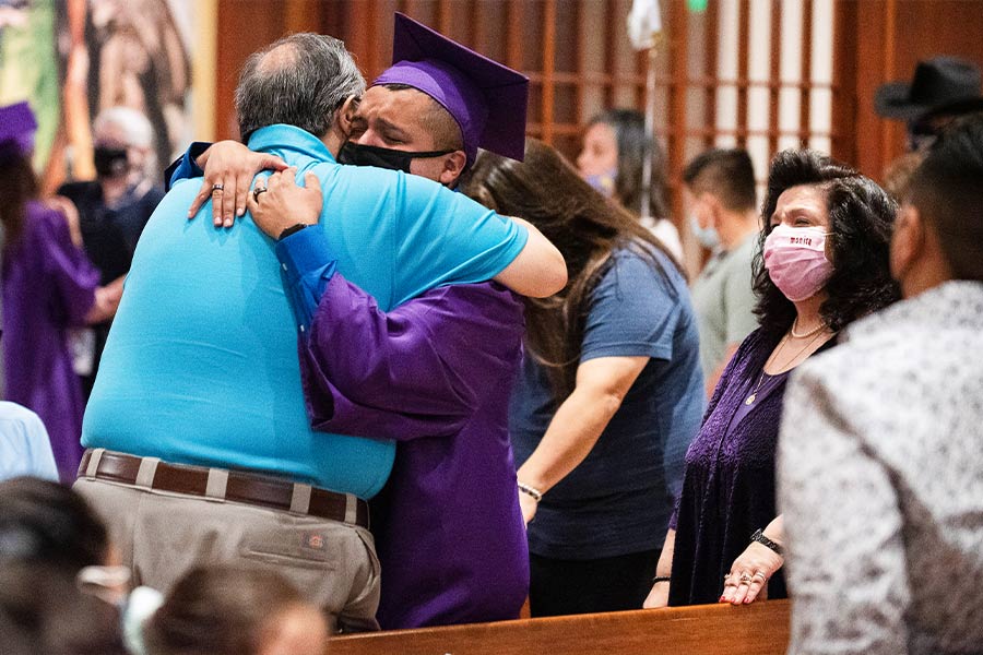 Graduate Xavier Gonzalez hugs his father at the end of this year's commencement for Cassata Catholic High School, on May 22, 2021 at St. Andrew Catholic Church in Fort Worth. (NTC/Ben Torres)