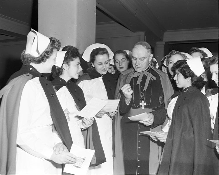 Diocese of Dallas Coadjutor Bishop Thomas K. Gorman visits with young nurses from Saint Joseph Hospital School of Nursing in 1952 at St. Patrick Catholic Church, before it became a cathedral. (Fort Worth Star-Telegram Collection, UTA Libraries)
