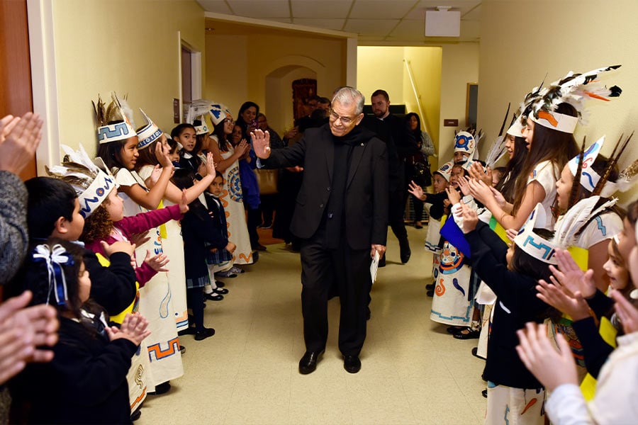 Fr. Esteban Jasso is greeted by young matachines from All Saints Catholic School at a reception celebrating his retirement as pastor of All Saints Catholic Church, on Dec. 15, 2017 in Fort Worth. (NTC photo/Ben Torres)