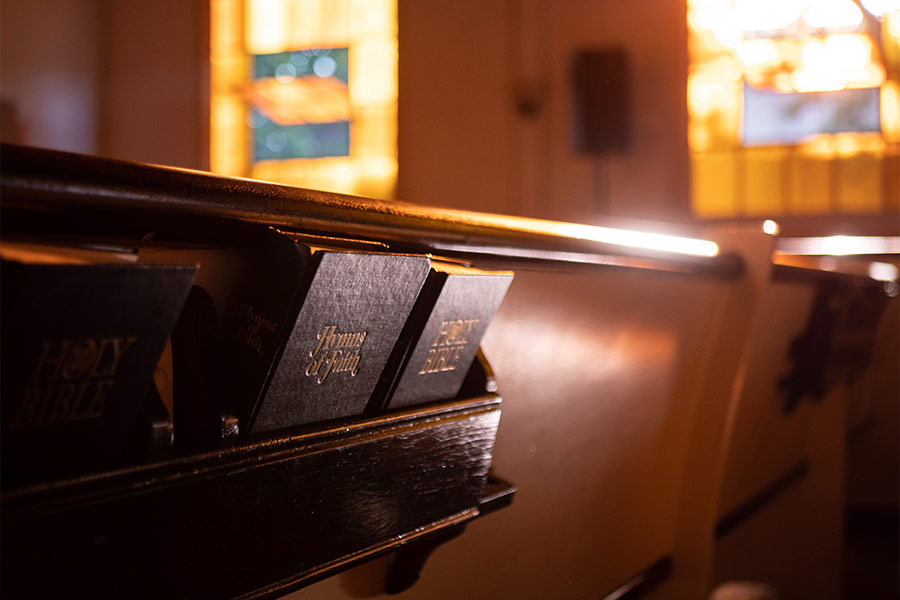 Photo of hymnals in the back of a pew.