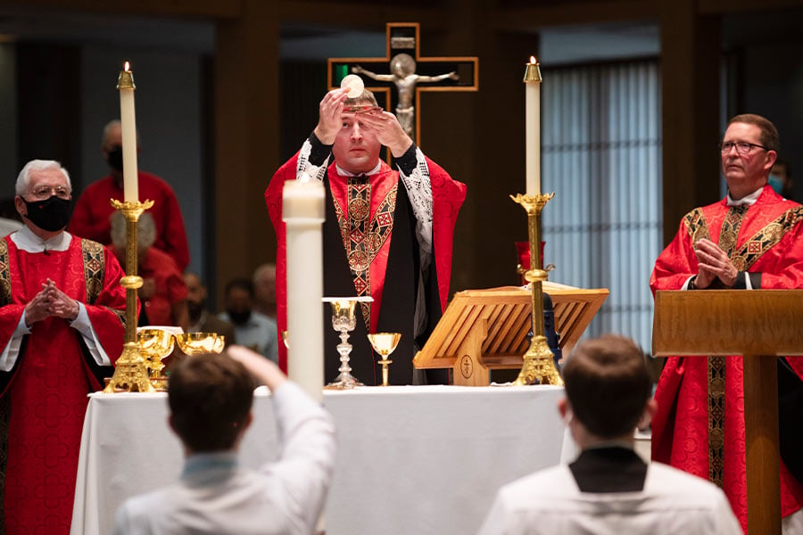 Fr. Thomas Jones, center, elevates the Body of Christ as he celebrates his first Mass at St. Philip the Apostle in Lewisville, on May 23, 2021. (NTC/Ben Torres)