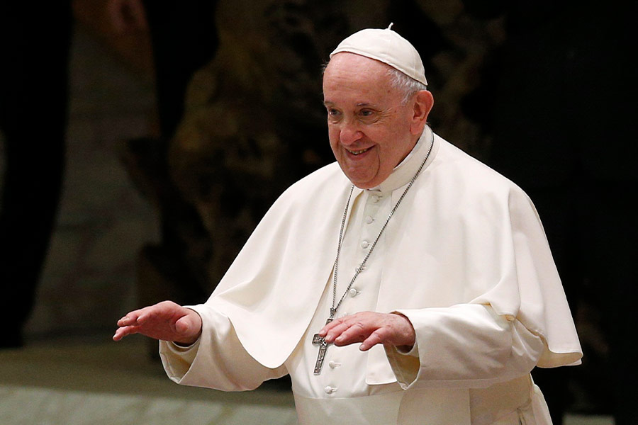 Pope Francis gestures for the crowd to be seated as he begins his general audience in the Paul VI hall at the Vatican Dec. 15, 2021. (CNS photo/Paul Haring)