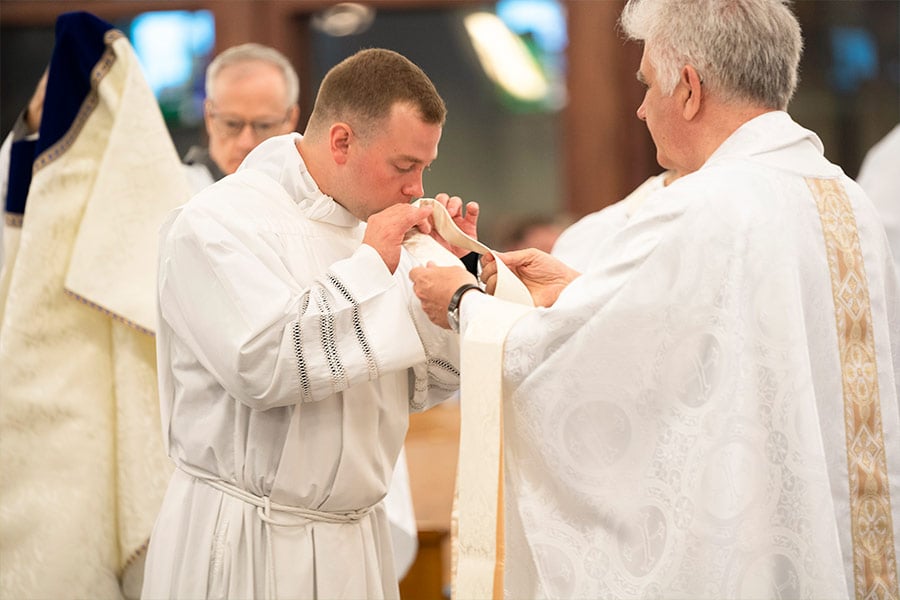 Father Brett Metzler kisses his stole during the priestly ordination Mass May 22, 2021 at Vietnamese Martyrs Parish in Arlington. (NTC/Jayme Donahue)