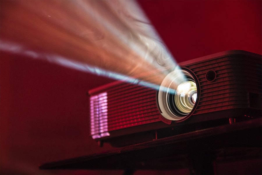 Close-up of a film projector in a dark room (Unsplash.com/Alex Litvin)
