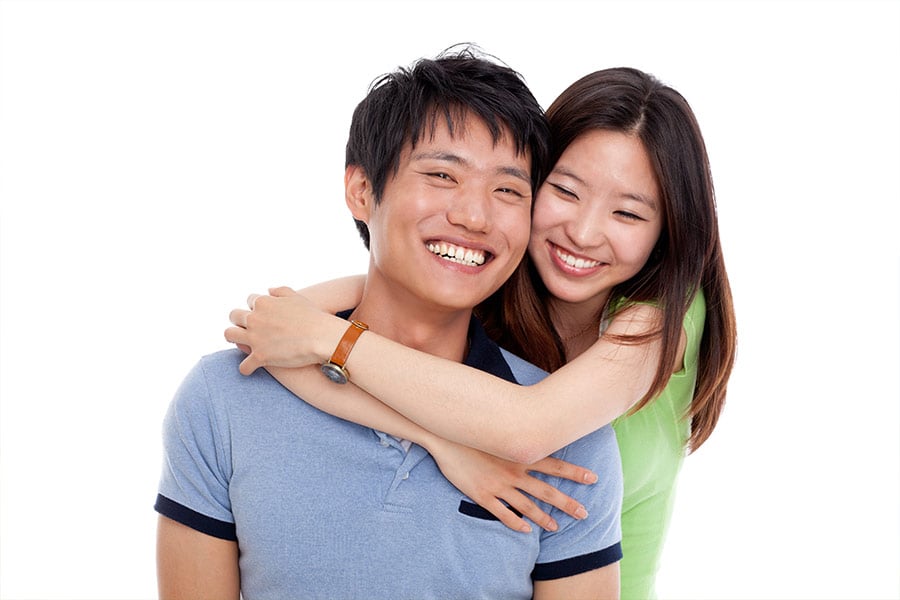 Photo of a smiling Asian couple against a white background