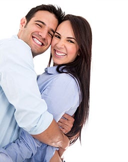 Photo of a smiling Latino couple against a white background