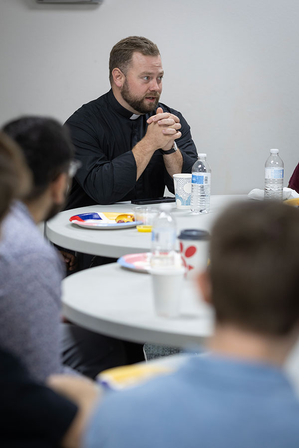 Fr. Metzler at table with young men
