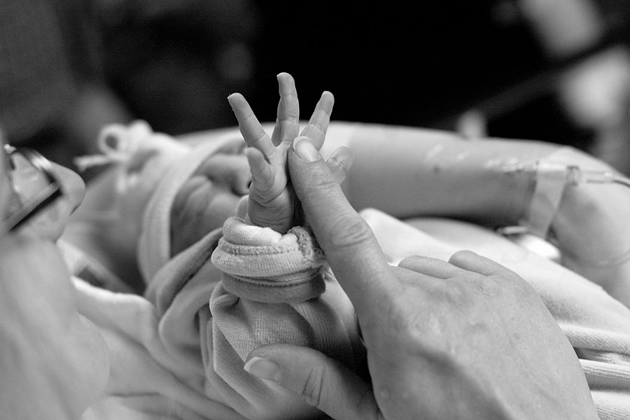 b&w photo of mother's hand and baby's hand