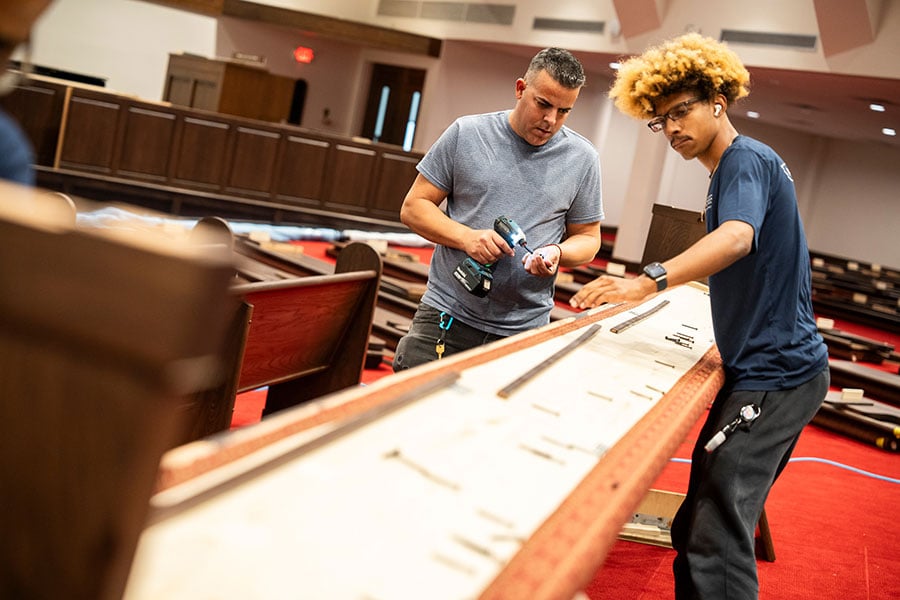 men assembling pews