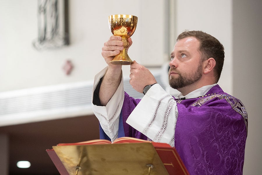 Fr. Metzler elevates the chalice