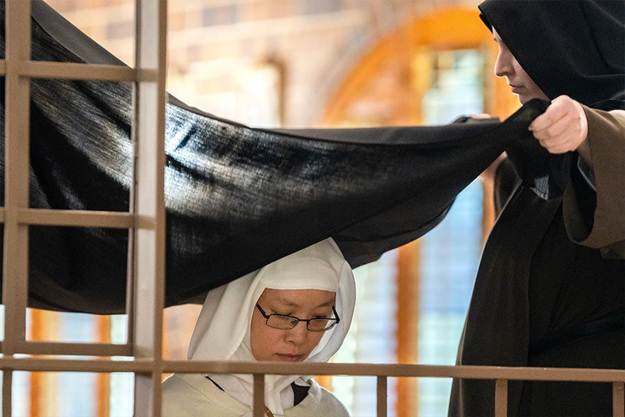 Sister Marie Therese of the Holy Face of Jesus, OCD, is clothed in the new veil during the liturgy for profession of solemn vows on May 31, 2022 at Carmel of the Most Holy Trinity. (NTC/Juan Guajardo)