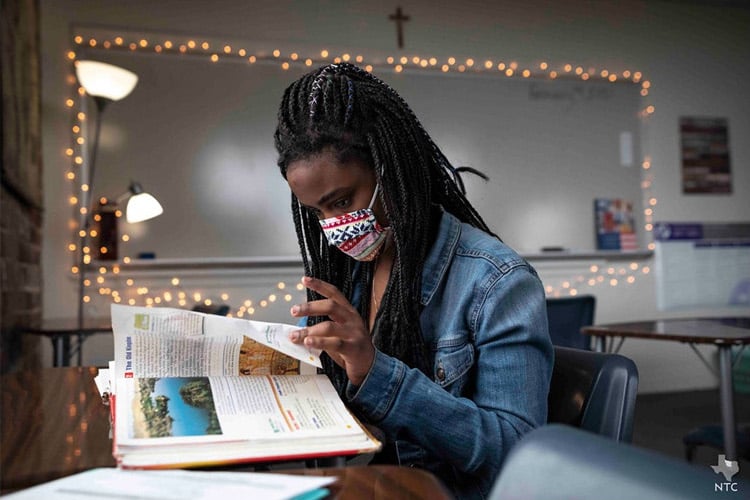 Fiona Schoonover reads from a book while taking notes in a social studies class at Cassata Catholic High School in Fort Worth, on Thursday, Feb. 04, 2021.